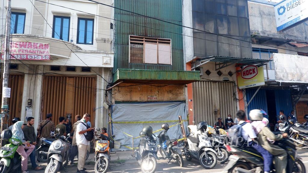 Warga melintas di depan Toko Haji Ali di kawasan Pasar Baru, Kota Banjarmasin, Kalimantan Selatan, yang runtuh saat direnovasi pada Selasa (27/9/2022). Dalam peristiwa itu, empat orang terjebak di dalam bangunan ruko, tetapi bisa dievakuasi dalam keadaan selamat.