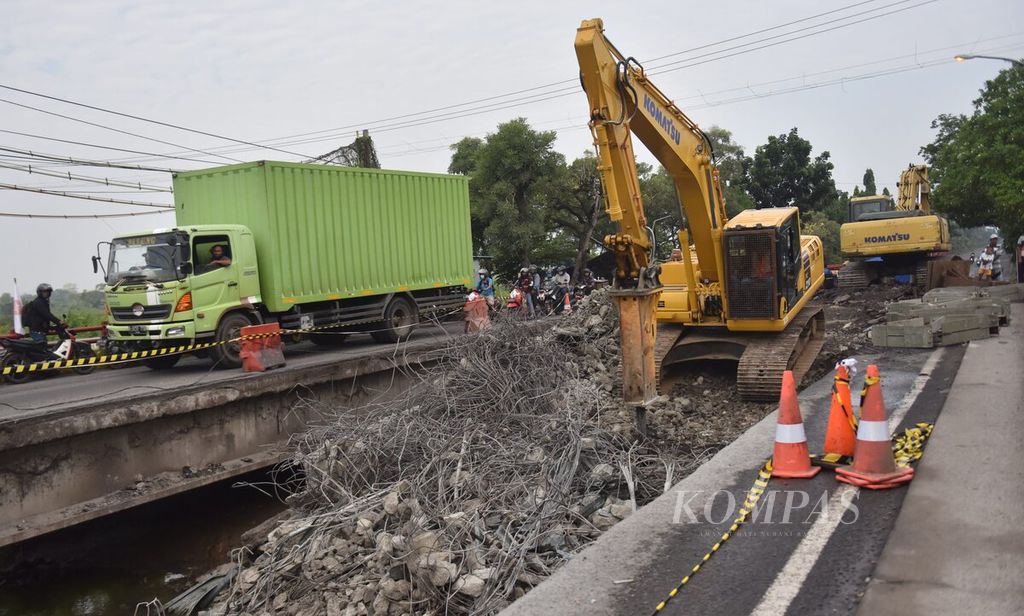 Truk melintasi ruas jembatan yang tersisa saat proses penghancuran bagian Jembatan Ngaglik 1 yang ambles di Kabupaten Lamongan, Jawa Timur, Rabu (30/3/2022). 