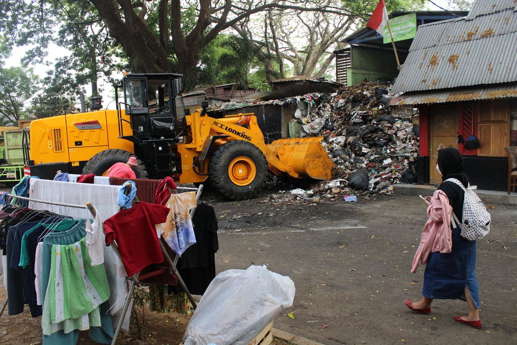 Warga melintasi Tempat Pembuangan Sampah Taman Cibeunying, Kota Bandung, Jawa Barat, Kamis (21/9/2023). Tumpukan sampah di TPS ini telah melebihi kapasitas sehingga mengganggu aktivitas masyarakat di sekitarnya.