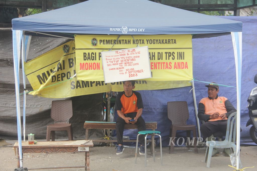 Petugas berjaga di depan tempat penampungan sementara (TPS) sampah di wilayah Kecamatan Gondokusuman, Kota Yogyakarta, yang tutup dan tidak melayani pembuangan sampah, Senin (24/7/2023). 