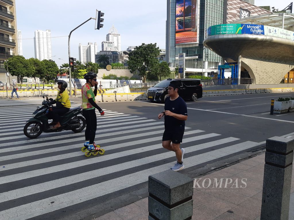Sejumlah warga berolahraga di ruas Jalan Sudirman-Thamrin, Minggu (7/4/2024).