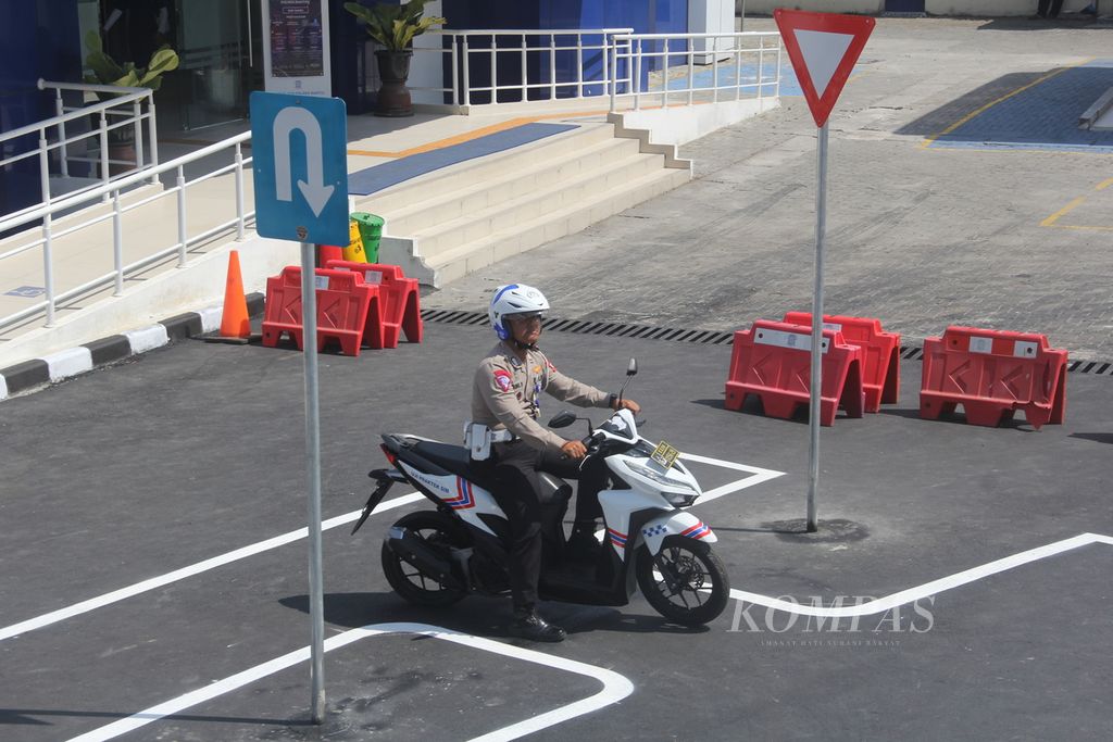 Seorang anggota Polri berhenti melewati putaran balik dalam simulasi ujian praktik surat izin mengemudi (SIM) dengan konsep baru, Senin (26/6/2023), di Markas Kepolisian Resor Bantul, Daerah Istimewa Yogyakarta. 