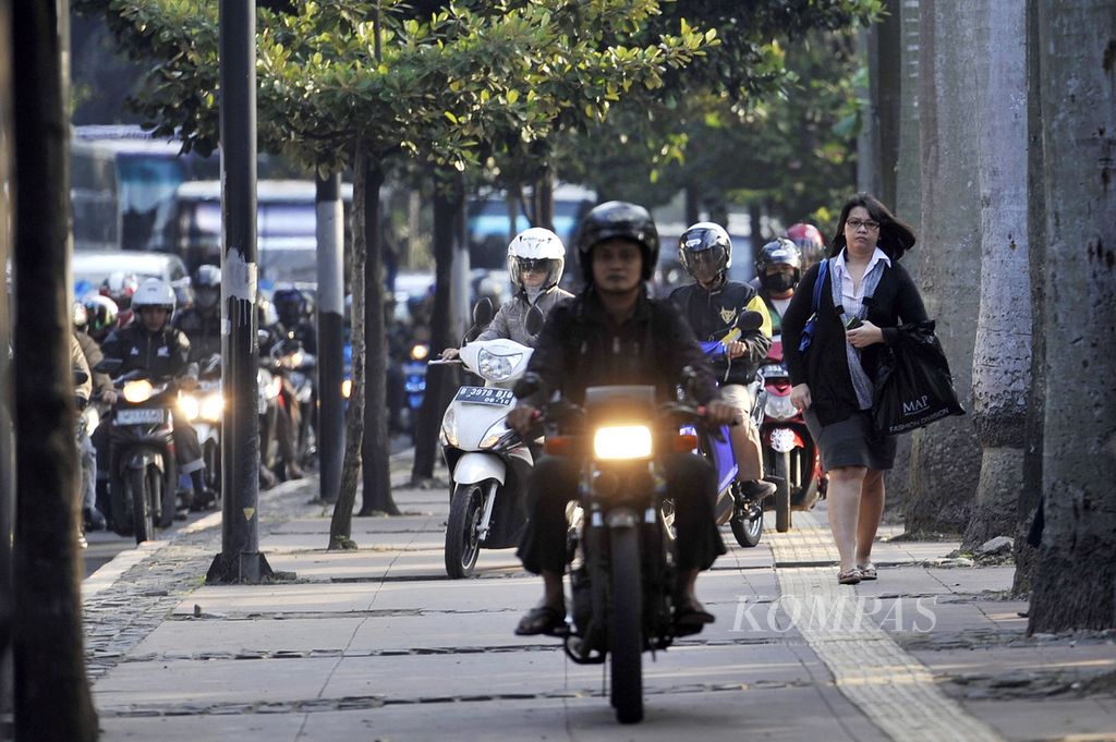 Para pengendara sepeda motor menghindari kemacetan dengan menerabas trotoar di Jalan Jenderal Sudirman, Senayan, Jakarta, Selasa (16/7/2013). Selain mengganggu kenyamanan pejalan kaki, tindakan para pengendara ini juga bisa mempercepat kerusakan trotoar. 