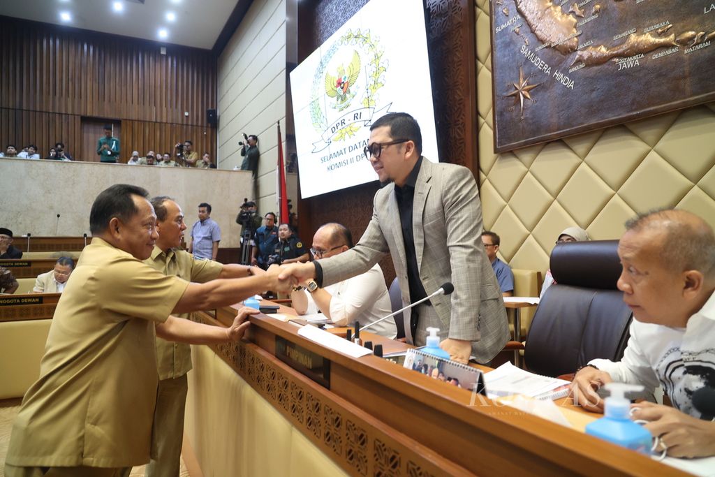 Menteri Dalam Negeri Tito Karnavian (kiri) bersalaman dengan Ketua Komisi II DPR Ahmad Doli Kurnia sebelum mengikuti rapat kerja dengan Komisi II DPR di Kompleks Parlemen, Senayan, Jakarta, Senin (25/3/2024). 