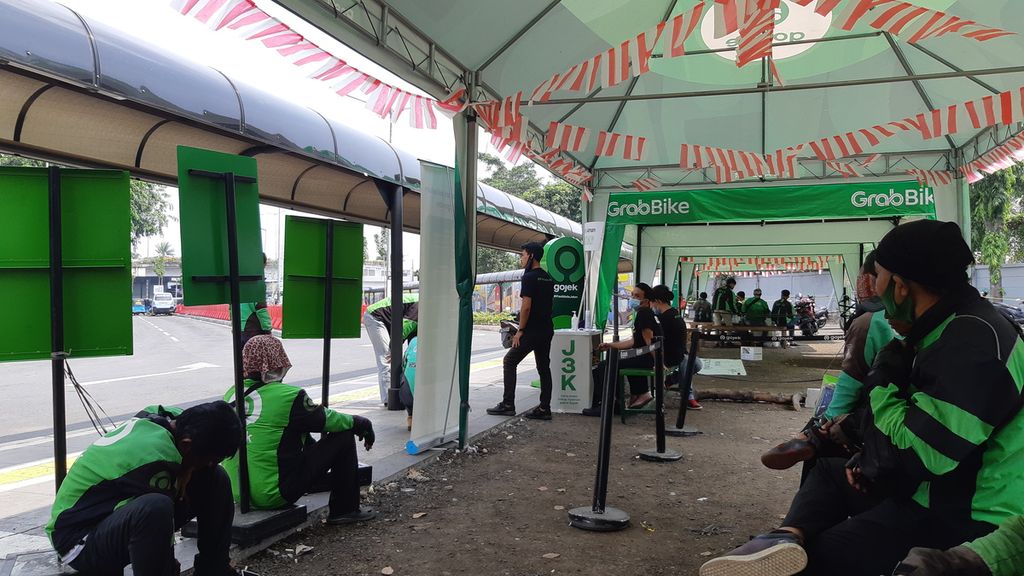 Pengojek daring menunggu penumpang di stan ojek daring, Stasiun Tanah Abang, Jakarta Pusat, Senin (10/8/2020).