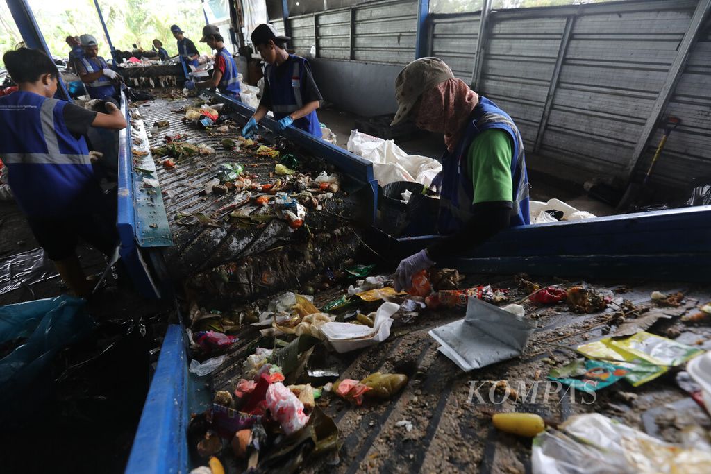 Pekerja memilah sampah organik dan anorganik dari rumah tangga dengan sabuk konveyor di bengkel produksi penyedia jasa pengolahan sampah Rumah Pemulihan Material (RPM) Waste4Change Bekasi 2.0 di kawasan Padurenan, Mustika Jaya, Bekasi, Jawa Barat, Selasa (8/3/2023). 