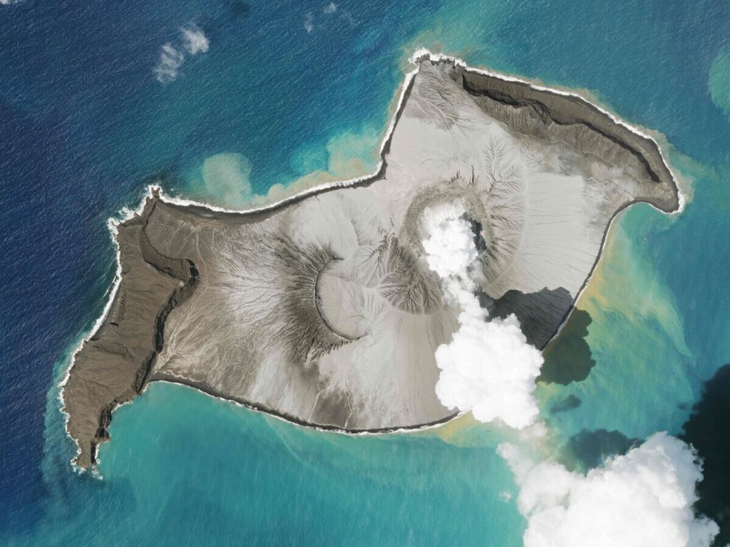 Citra satelit yang diambil Planet Labs PBC menunjukkan, sebuah pulau yang diciptakan gunung berapi bawah air Hunga Tonga terlihat berasap, pada 7 Januari 2022. Sebuah gunung berapi bawah laut meletus atau mengalami erupsi secara spektakuler di dekat negara Pasifik Tonga, Sabtu (15/1/2022), memicu gelombang tsunami yang menerjang pantai, 
