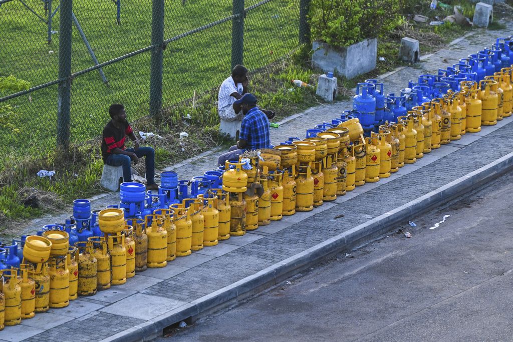 People queue along a street to buy Liquefied Petroleum Gas (LPG) cylinders near the Galle International Cricket Stadium in Galle on June 28, 2022.