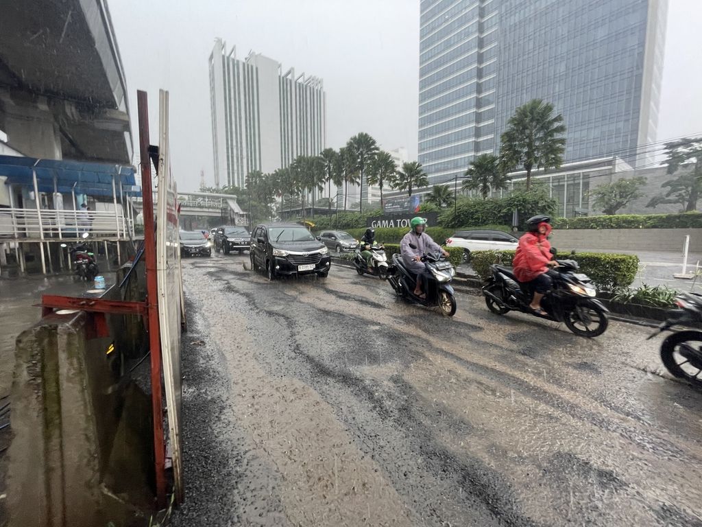 Kendaraan melintas di depan Halte Kementerian Kesehatan di Jalan Haji Rasuna Said, Jakarta Selatan, Jumat (3/3/2023). Aspal berlubang ada di lajur kanan sepanjang dua meter jalan tersebut. Lubang-lubang itu seperti melebur jadi satu dan menciptakan ”kolam” saat turun hujan.