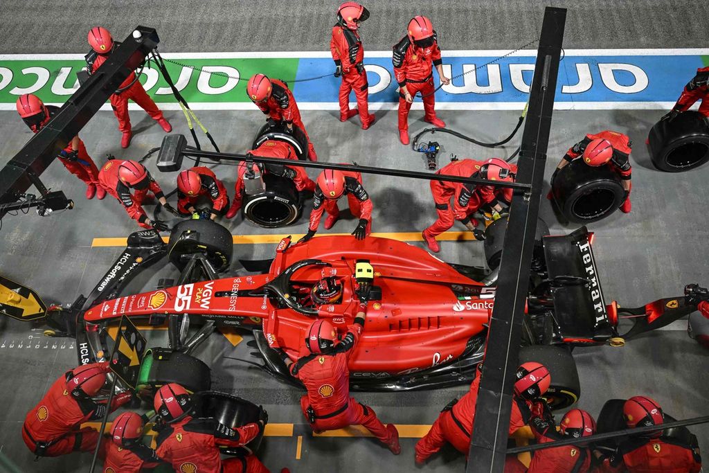 Para mekanik Ferrari menangani mobil pebalap Carlos Sainz Jr di <i>pit lane</i> saat balapan Grand Prix Formula 1 seri Singapura di Sirkuit Jalan Raya Marina Bay, Singapura, Minggu (17/9/2023). 