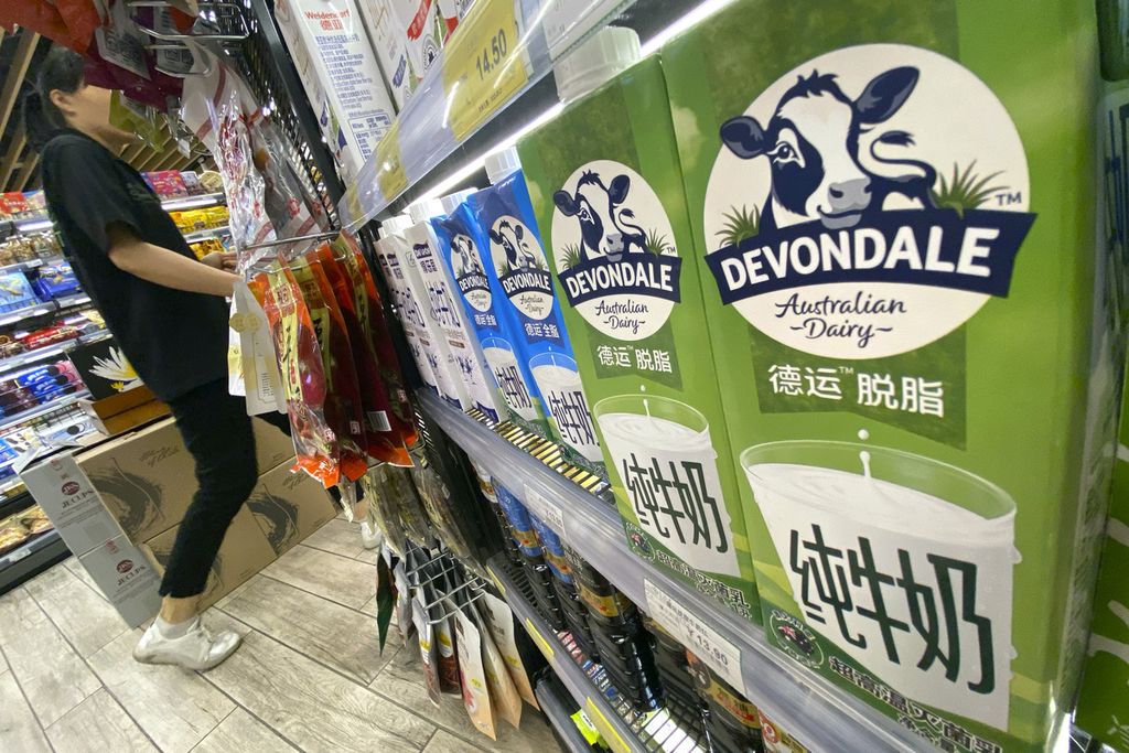 Seorang pembeli tengah berjalan melintasi rak yang menawarkan susu kemasan produksi Australia, Devondale, di sebuah supermarket di Beijing, China pada Jumat (12/5/2023).