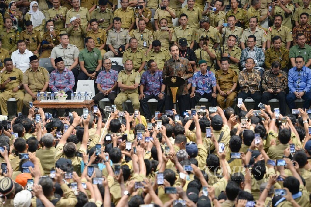Para perangkat desa berusaha mengabadikan Presiden Joko Widodo yang tengah berpidato dalam Silaturahim Nasional Persatuan Perangkat Desa Indonesia di Istora, Senayan, Jakarta, Senin (14/1/2019).