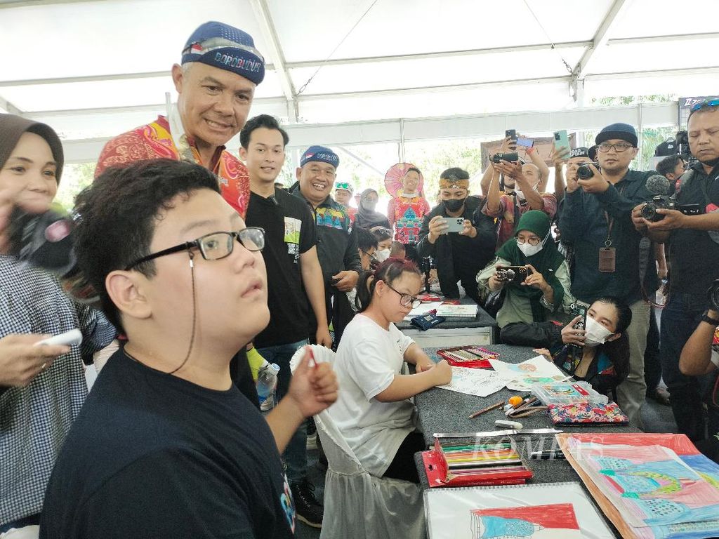  Gubernur Jawa Tengah Ganjar Pranowo menyapa sejumlah anak yang sedang asyik menggambar dalam ajang pameran yang digelar dalam acara Tour de Borobudur di Taman Lumbini, kompleks Taman Wisata Candi Borobudur, Minggu (6/11/2022).
