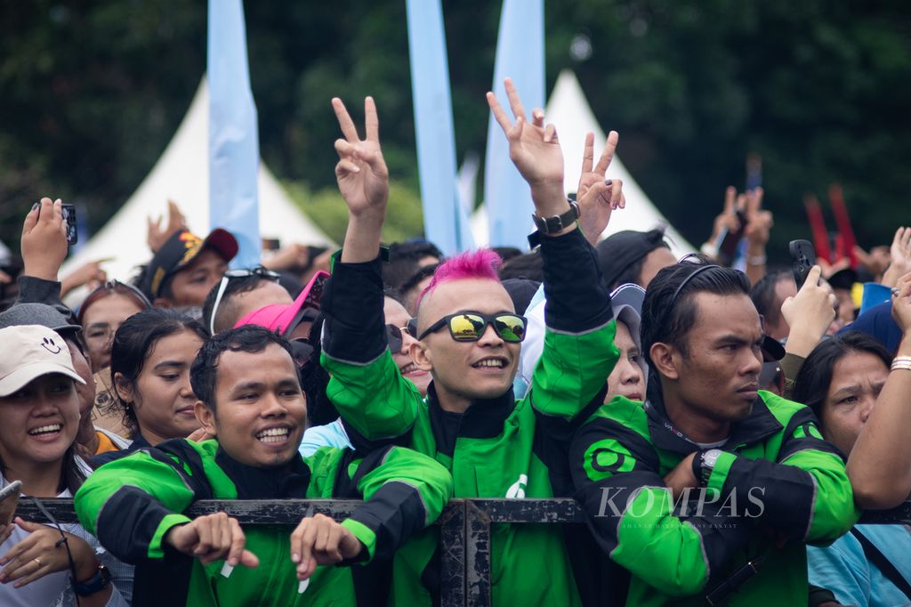 Tiga pengemudi ojek daring menonton hiburan dangdut jelang acara Silaturahmi Relawan Prabowo Subianto di halaman Stadion Tumenggung Abdul Jamal, Batam, Kepulauan Riau, Sabtu (13/1/2024).