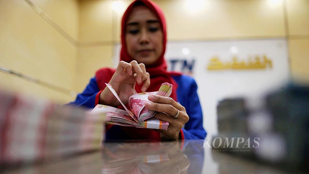 Pegawai bank menghitung uang kertas rupiah di Banking Hall BTN Syariah di kawasan Harmoni, Jakarta, Kamis (30/3). Berdasarkan kurs referensi Jakarta Interbank Spot Dollar Rate, kemarin nilai tukar rupiah menguat 7 poin menjadi Rp 13.316 per dollar AS dibandingkan dengan hari sebelumnya.