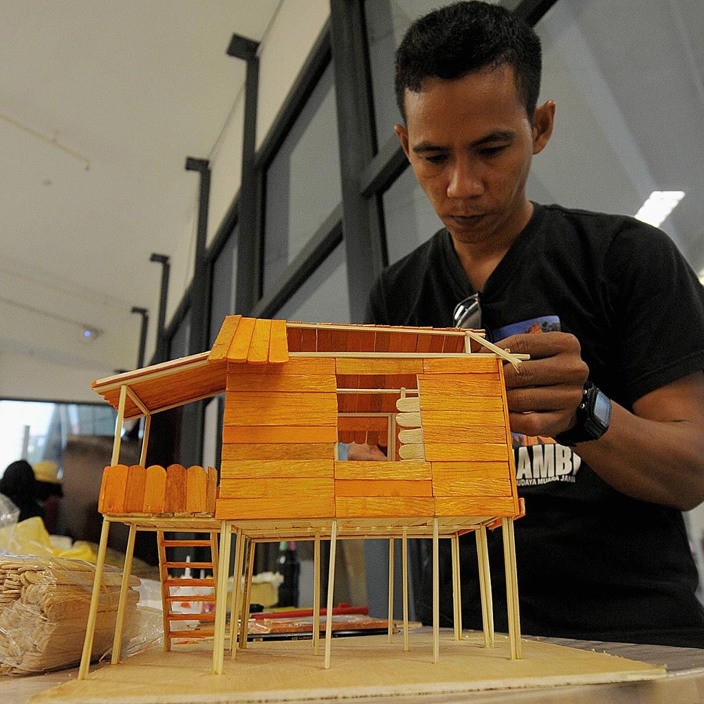 Seniman Jambi membuat miniatur rumah tradisional yang akan dia pemerkan dalam ajang Singapore Art Week, rabu (24/1).