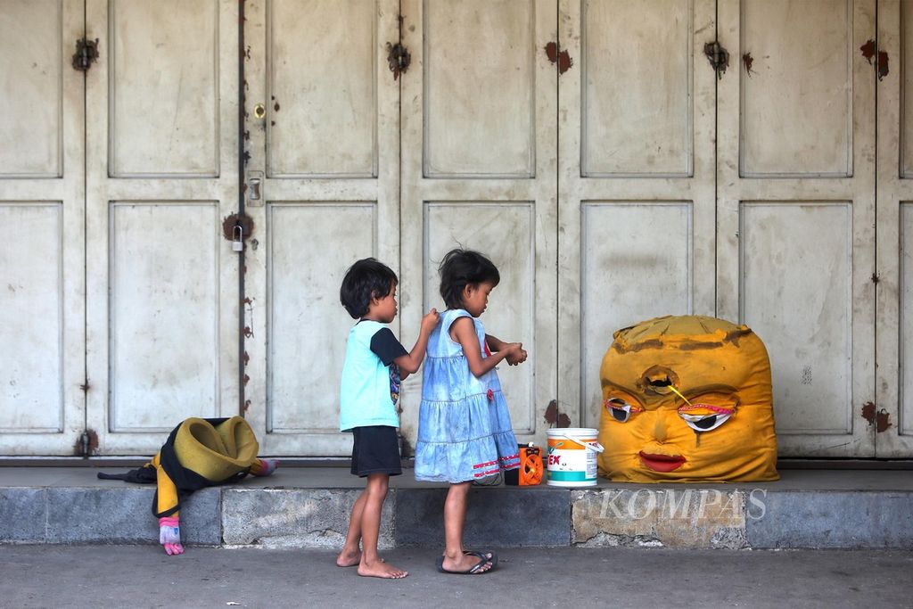 Dua bocah tengah berisitrahat di sela-sela waktunya berkeliling mencari uang sebagai pengamen boneka di kawasan Pisangan Baru, Matraman, Jakarta, Minggu (23/8/2020). 