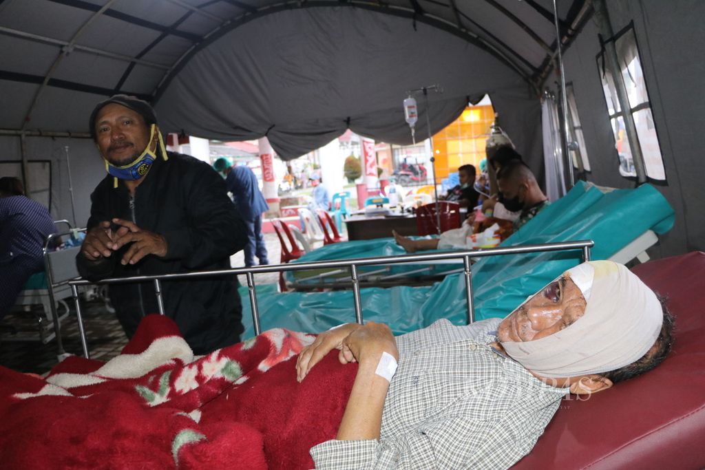 Proklamasi Panti Hutabarat (53) dirawat di tenda darurat di Rumah Sakit Umum Daerah Tarutung karena terluka akibat gempa bumi berkekuatan M5,8 di Kabupaten Tapanuli Utara, Sumatera Utara, Sabtu (1/10/2022). Satu orang meninggal, 11 orang terluka, serta sedikitnya 76 rumah dan rumah ibadah rusak akibat gempa itu.