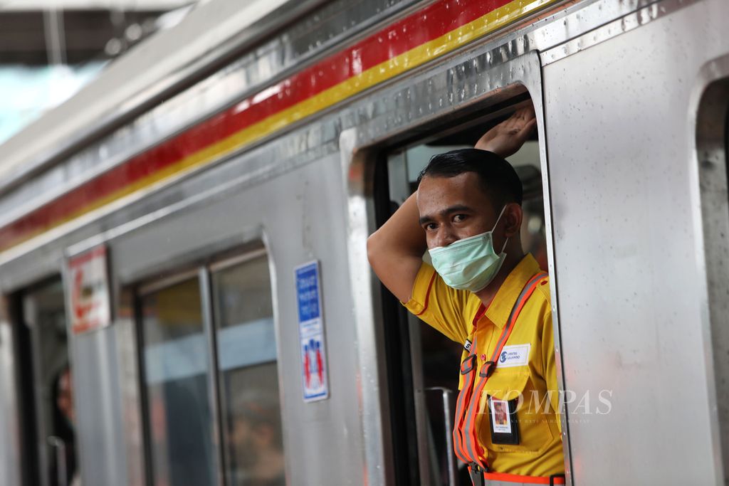 Petugas kereta rel listrik (KRL) Commuterline mengenakan masker di Stasiun Tanah Abang, Jakarta, Senin (3/2/2020). Sebagai antisipasi dan respons terhadap penyebaran virus korona, petugas KRL membagikan masker kepada penumpang KRL.