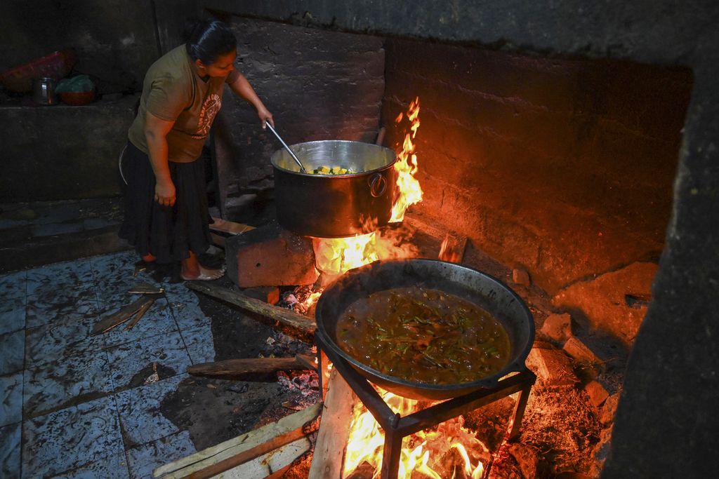 Seorang perempuan menggunakan kayu bakar untuk memasak di sebuah hotel di Colombo, Sri Lanka, 15 Maret 2022. Krisis ekonomi terburuk menyebabkan kelangkaan gas sehingga sebagian rakyat Sri Lanka berbalik menggunakan kayu bakar. 