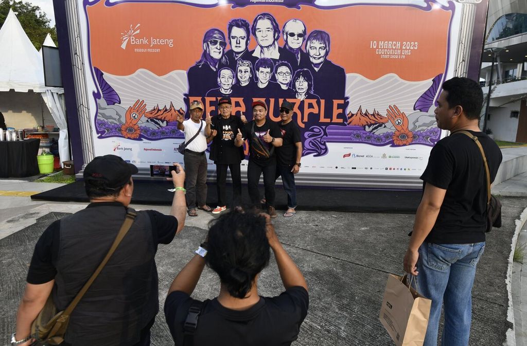 Penonton berfoto dengan latar belakang gambar Deep Purple sebelum memasuki area konser Deep Purple di Edutorium UMS, Surakarta, Jawa Tengah, Jumat (10/3/2023). 