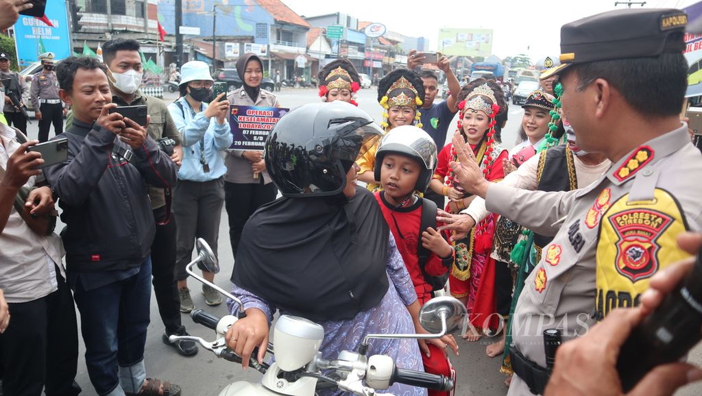 Polisi menghentikan pengendara yang tidak mengenakan helm di Pos Palimanan, Kabupaten Cirebon, Jawa Barat, Selasa (7/2/2023). Selain mengimbau terkait keselamatan berkendara, polisi juga memberikan helm gratis kepada warga tersebut. Kegiatan yang digelar Kepolisian Resor Kota Cirebon itu dalam rangka Operasi Keselamatan Lodaya yang berlangsung pada 7-20 Februari 2023 di sejumlah daerah.