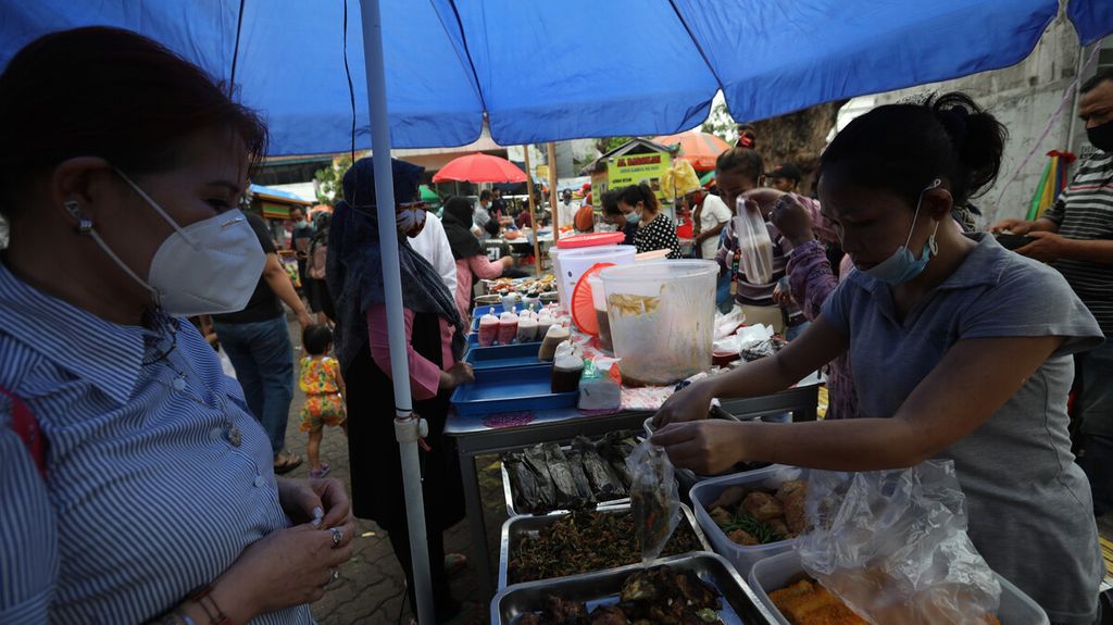 Pedagang makanan takjil untuk berbuka puasa melayani pembeli di Pasar Rawamangun, Jakarta Timur, pada 2021. Pasar takjil ini merupakan salah satu sentra makanan musiman yang ramai dikunjungi warga saat menjelang berbuka puasa. Pedagang pasar takjil musiman memanfaatkan momentum bulan puasa untuk meraup rezeki. 