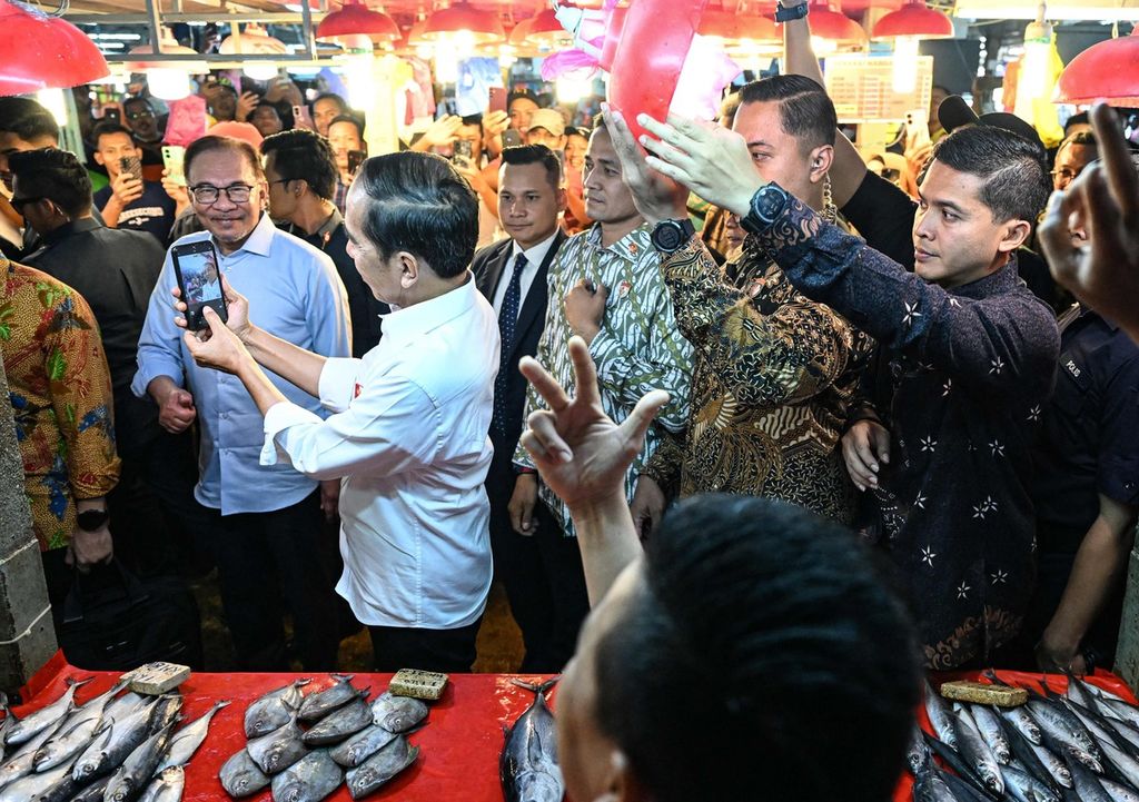 Presiden Joko Widodo memenuhi permintaan warga untuk berswafoto dalam kunjungan ke Pasar Chow Kit bersama Perdana Menteri Malaysia Anwar Ibrahim (kiri) di Kuala Lumpur, Malaysia, Kamis (8/6/2023). 
