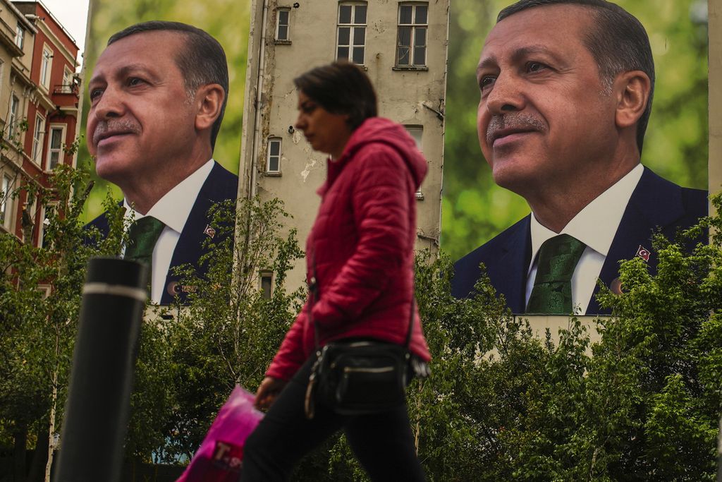 Seorang pria berjalan melewati baliho bergambar Presiden Turki dan kandidat Presiden dari Koalisi Kerakyatan, Recep Tayyip Erdogan, sehari seusai pemilu di Istanbul, Turki, Senin (15/5/2023). 
