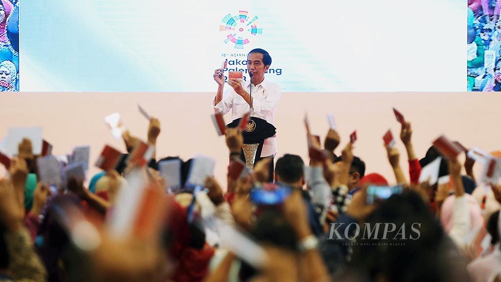 Presiden Joko Widodo menunjukkan kartu keluarga sejahtera (KKS) dan buku tabungan  dalam peluncuran bantuan pangan nontunai   di GOR POPKI, Cibubur, Jakarta Timur, Kamis (23/2). Bantuan pangan nontunai sebesar Rp 110.000 per bulan diberikan melalui KKS,  yang dapat digunakan untuk berbelanja kebutuhan pokok di e-warong. 