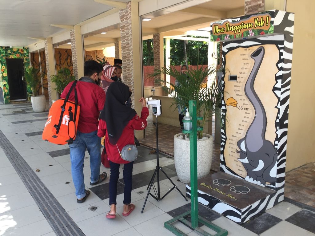 Warga memeriksa suhu tubuh sebelum masuk Kebun Binatang Surabaya, Jawa Timur, saat hari Lebaran, Senin (2/5/2022). KBS masih menjadi salah satu obyek wisata favorit warga yang tidak mudik saat Lebaran. Kunjungan membeludak di hari kedua Lebaran atau Selasa (3/5/2022) dengan peningkatan kunjungan 4-5 kali lipat daripada sehari sebelumnya.