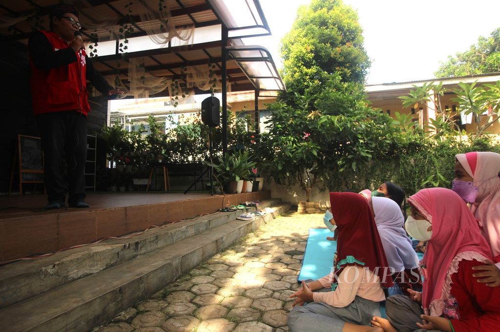Sejumlah anak mendengarkan dongeng yang diceritakan oleh pendongeng dari Kampung Dongeng Indonesia Yadi Mulyadi (kiri) di Ciputat, Tangerang Selatan, Banten, pada Hari Dongeng Sedunia, Minggu (20/3/2022). 