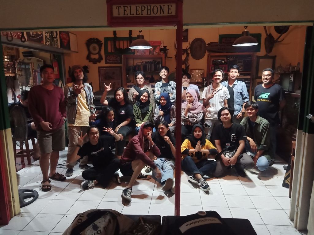Poetry fans who are members of the Manado Poetry Night community take a group photo after holding a poetry reading event at one of the cafes in Manado, 2020.