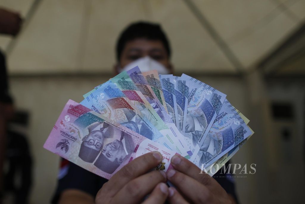 Petugas menunjukkan uang rupiah kertas emisi tahun 2022 saat Festival Rupiah Berdaulat yang diadakan Bank Indonesia di GOR Basket Gelora Bung Karno, Senayan, Jakarta, Jumat (19/8/2022). 