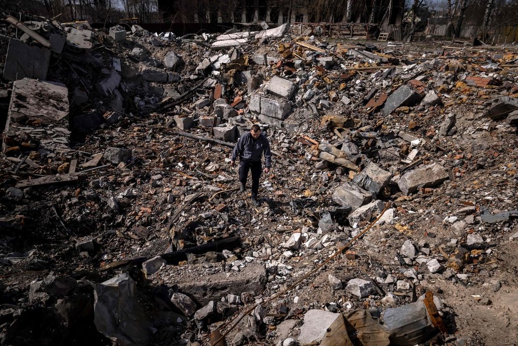 Seorang polisi tengah berjalan di reruntuhan bangunan rumah di Desa Bohdanivka, Kiev pada Kamis (14/4/2022).