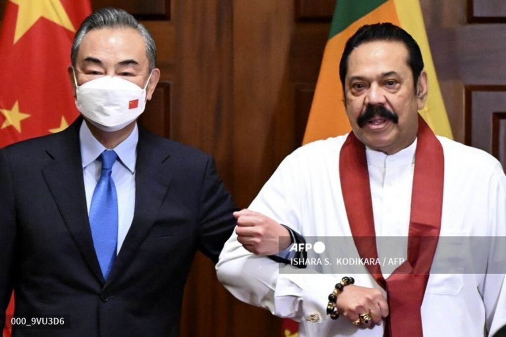 Menteri Luar Negeri China Wang Yi (kiri) berfoto bersama Perdana Menteri Sri Lanka Malinda Rajapaksa jelang pertemuan bilateral di Colombo, 9 Januari 2022. 