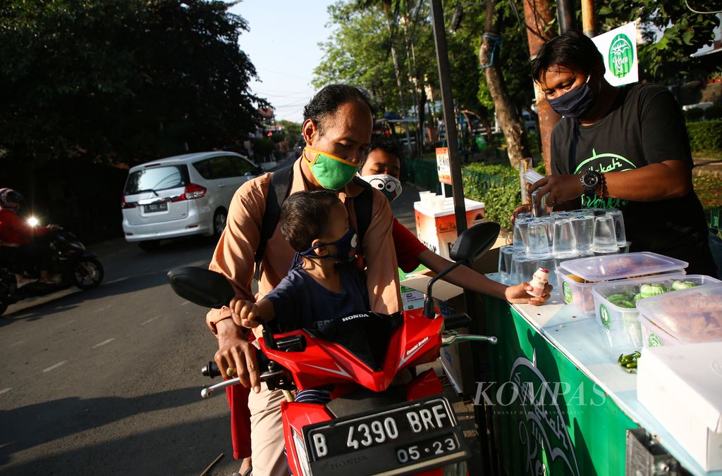 Warga mengambil minuman gratis yang disiapkan sukarelawan Sahabat Sedekah di kawasan perumahan DKI Joglo, Jakarta Barat, akhir Agustus 2020. 