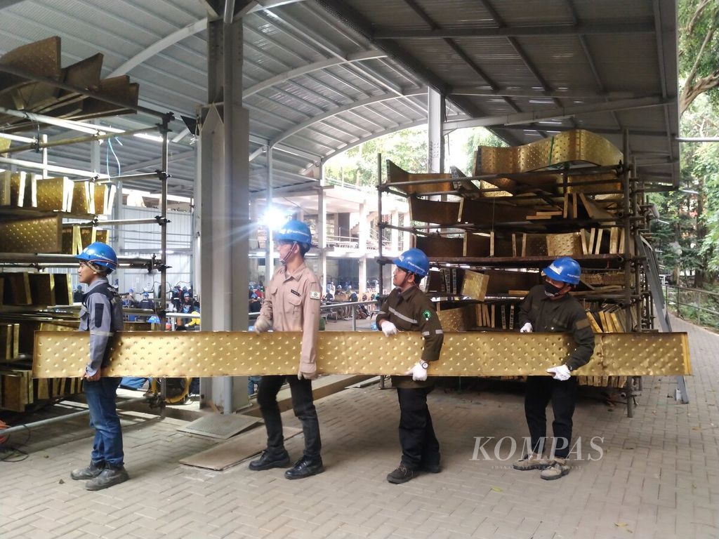 Pekerja membawa bilah logam kuningan di Nyoman Nuarta Art Space di Bandung, Jabar, Rabu (30/8/2023). Sebanyak 80 bilah logam kuningan atau delapan modul, masing-masing sepanjang 4,5 meter, sudah dikirimkan untuk menjadi bagian dari selubung istana presiden di Kalimantan Timur.