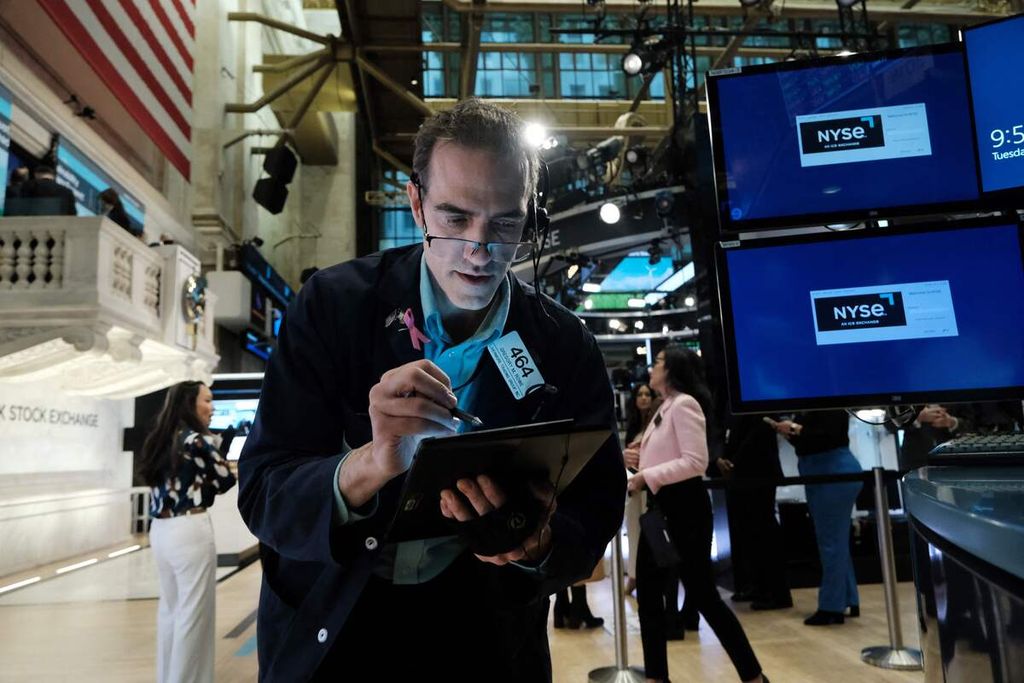 Para pedagang saham di lantai Bursa Saham New York (NYSE), Amerika Serikat, 28 Maret 2023. Saham-saham di bursa AS turut mengalami penurunan setelah penarikan besar-besaran dana nasabah di bank-bank AS.  
