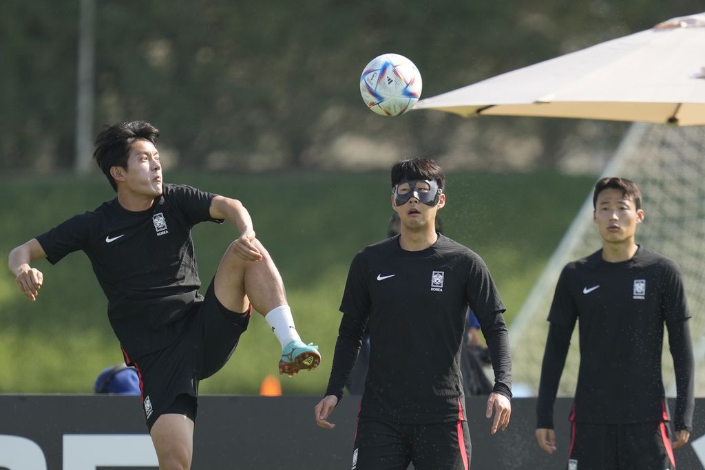 Pemain Korea Selatan, Son Heung-min (tengah) dan Son Jun-ho (kanan), melakukan pemanasan dalam sesi latihan di Al Egla Training Site 5, Doha, Minggu (4/12/2022). Brasil dan Korea Selatan akan berhadapan dalam laga babak 16 besar Piala Dunia Qatar pada Senin (5/12/2022) malam waktu setempat atau Selasa (6/12/2022) dini hari WIB. 