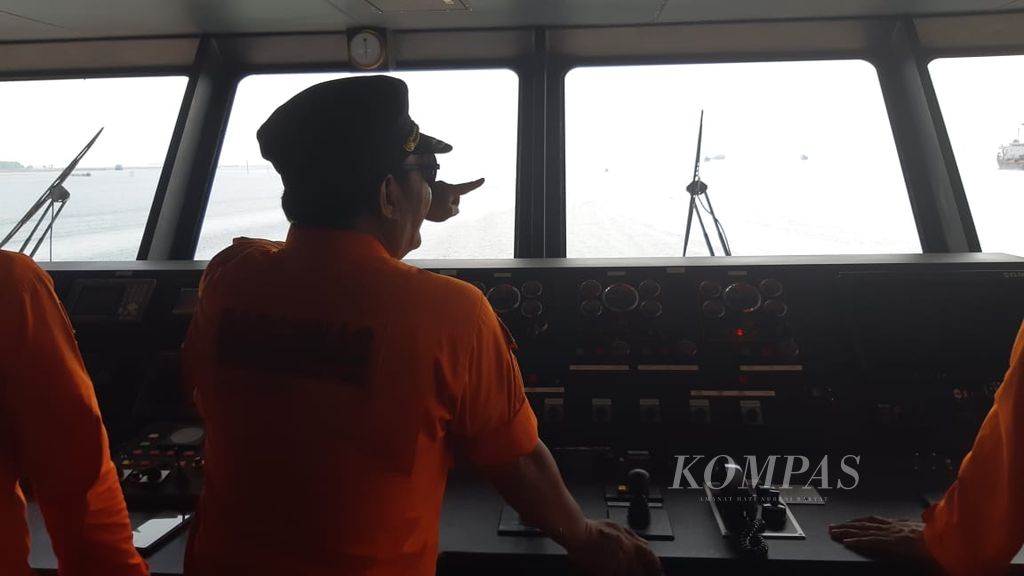 Ruslan, Kapten KN SAR Pacitan, memantau perairan selepas melalui Teluk Kendari, Sulawesi Tenggara, Sabtu (30/12/2023). Pengawasan perairan ditingkatkan seiring aktivitas warga di pergantian tahun.