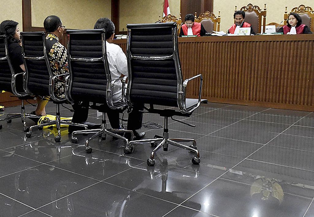 Ketua majelis hakim perkara korupsi KTP elektronik dengan terdakwa Andi Narogong,  Jhon Halasan Butarbutar (kedua dari kanan), mendengarkan keterangan saksi dalam sidang lanjutan di Pengadilan Tindak Pidana Korupsi Jakarta, Jumat (20/10). Ketua DPR Setya Novanto, yang juga dijadwalkan menjadi saksi, tidak hadir dalam sidang perkara tersebut. 