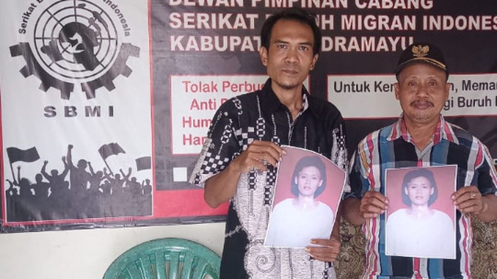 Ketua SBMI Indramayu Akhmad Zaenuri (kiri) menunjukkan foto Ruminih Sarman (48), pekerja migran Indonesia asal Kabupaten Indramayu, Jawa Barat, Minggu (30/10/2022). Sudah 11 tahun keluarga tidak bisa menghubungi Ruminih yang bekerja di Arab Saudi.