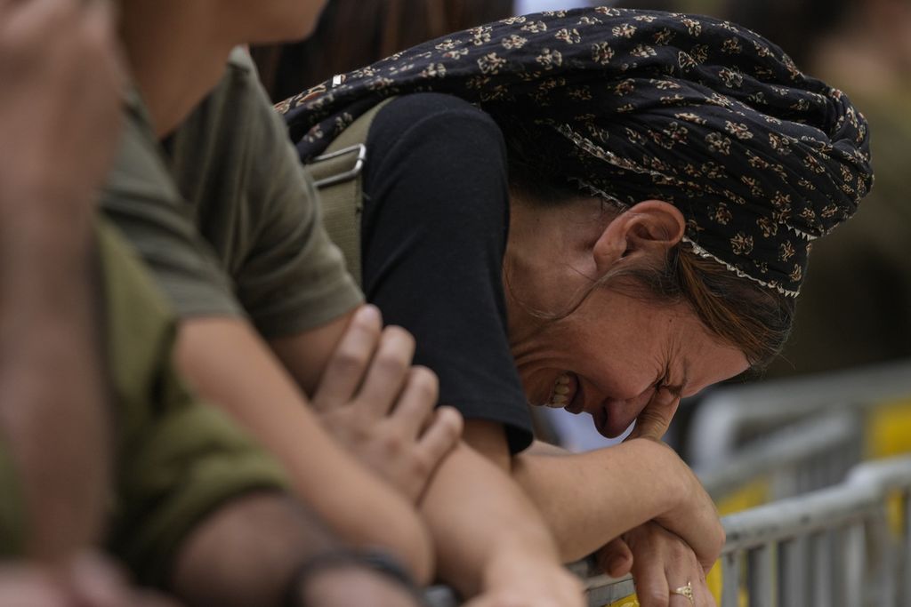 Seorang wanita menangis saat pemakaman kolonel Israel, Roi Levy, di pemakaman Mount Herzl di Jerusalem, Senin (9/10/2023). Kolonel Levy terbunuh setelah Hamas menyerbu dari Jalur Gaza yang diblokade ke kota-kota terdekat di Israel.