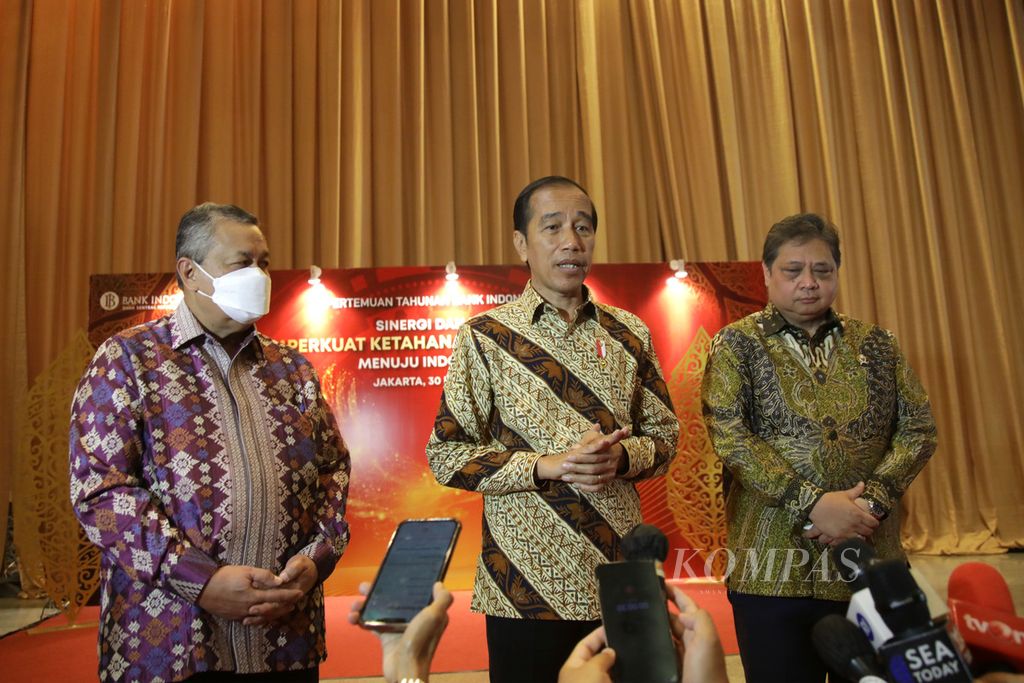 Presiden Joko Widodo didampingi Gubernur Bank Indonesia Perry Warjiyo (kiri) dan Menko Perekonomian Airlangga Hartarto menjawab pertanyaan wartawan seusai menghadiri Pertemuan Tahunan Bank Indonesia 2022 di Jakarta, akhir November 2022. 