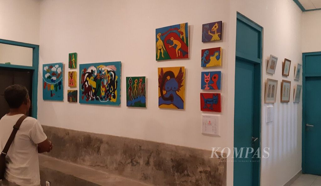 Pengunjung melihat lukisan yang dipajang di Dalam Rumah Art Station, Kota Denpasar, dalam serangkaian pameran bertajuk bertajuk Silang Sengkarut yang dimulai Minggu (8/5/2022).