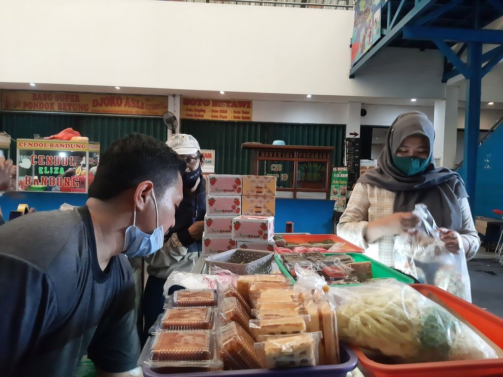 Ilham (31), penjual kue basah, melayani pembeli di Harmony Swalayan, Pondok Aren, Tangerang Selatan, Kamis (23/3/2023).