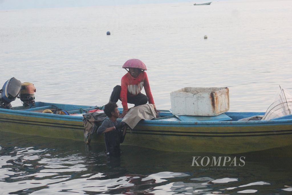 Dengan cara memanggul menyeberangi pantai, seorang nelayan membawa seekor ikan tuna segar yang baru saja ditangkap menuju tempat penimbangan di Desa Sangowo, Kecamatan Morotai Timur, Kabupaten Pulau Morotai, Maluku Utara, Rabu (27/7/2022).
