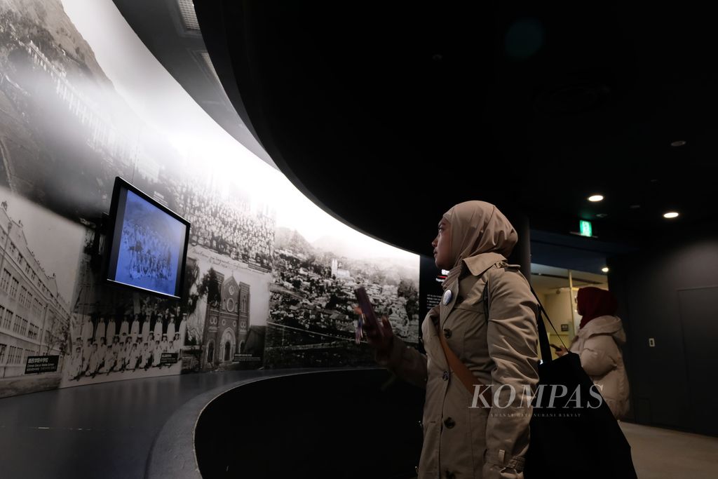 Seorang wisatawan mengamati narasi sejarah yang ditampilkan di Museum Bom Atom Nagasaki, Nagasaki, Jepang, pada Jumat (26/1/2024). Museum ini dibuka untuk publik pada 1996 untuk mengenang sejarah Jepang, sekaligus untuk menyebarkan narasi perdamaian dunia.