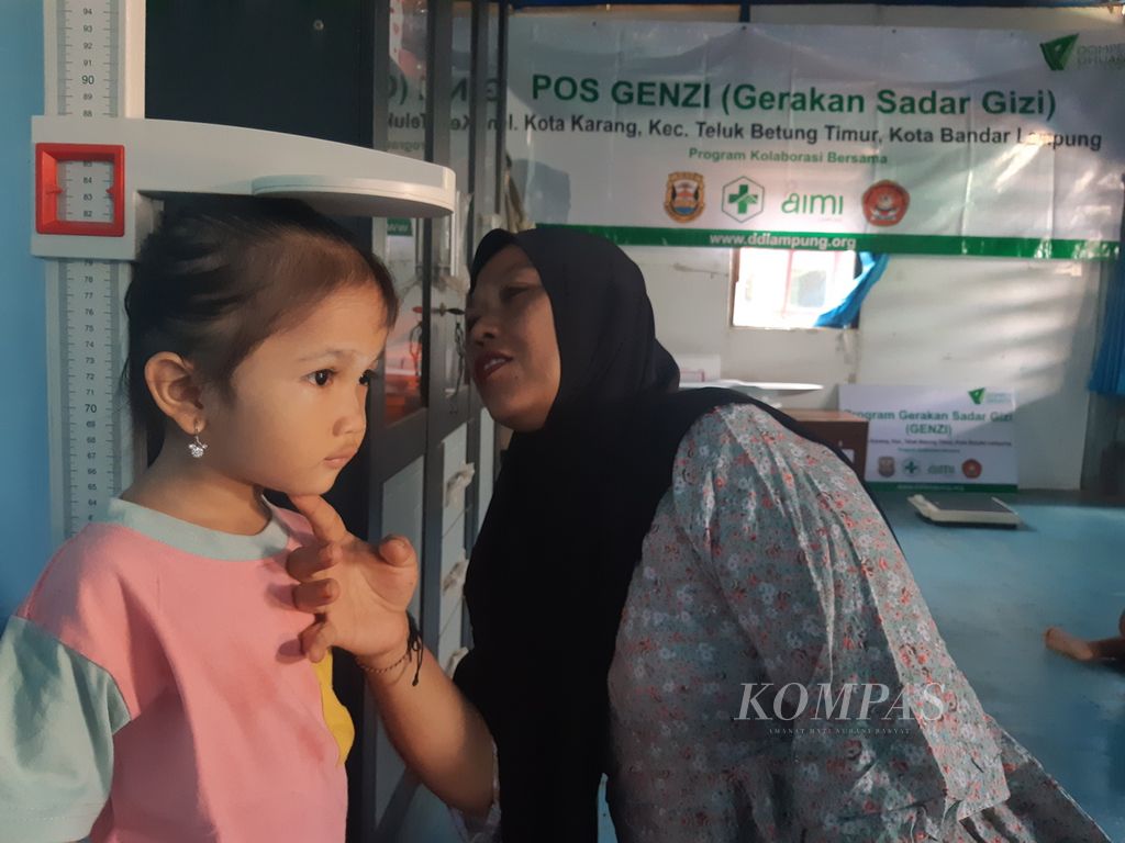 Seorang kader posyandu sedang mengecek tinggi badan anak balita, Rabu (31/7/2024). Kelompok masyarakat di Lampung menginisiasi program sadar gizi dengan memberikan bantuan makanan bergizi dan pendampingan pada orangtua.